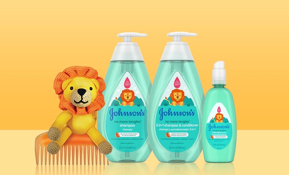 Johnson's No More Tangles shampoo, 2-in-1 shampoo and conditioner, and detangling spray bottles with a lion toy and comb.