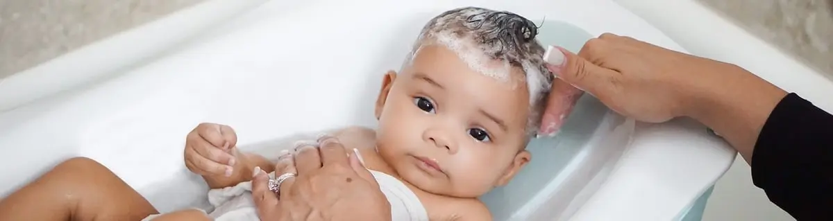 Baby being bathed with gentle lather on head, representing Johnsons Baby care.