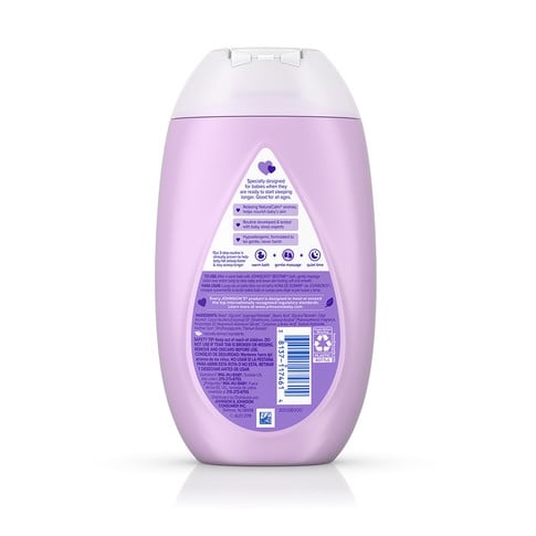 A lavender-colored bottle labeled "Johnsons Baby Shampoo" with a white cap, standing on a reflective surface. The label includes product details in multiple languages and an illustrated baby face.