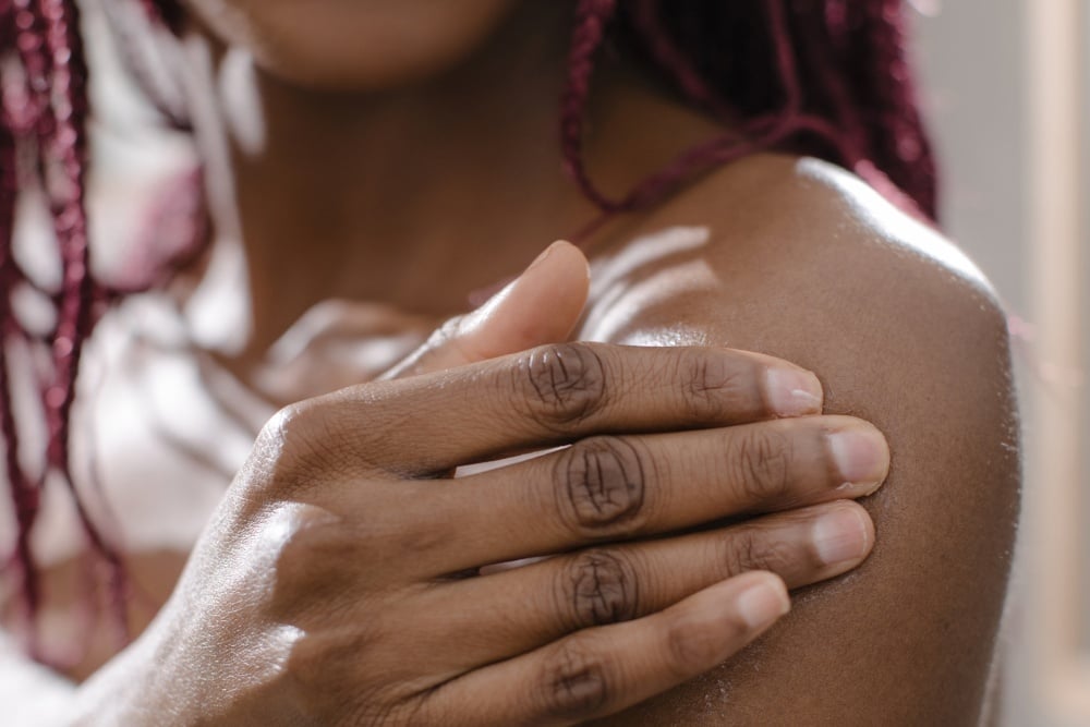 Woman applying DIY body scrub to arm