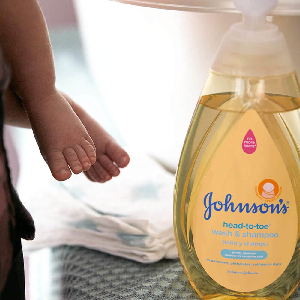 Johnson's head-to-toe wash & shampoo bottle beside a baby's feet, 27.1 fl oz (800 ml), suitable for newborns, labeled as free from parabens, phthalates, sulfates, or dyes.