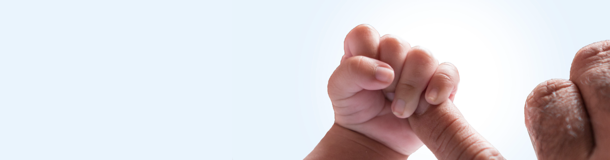 Baby's hand gently holding their parent's finger against a light blue background, symbolizing care and connection.