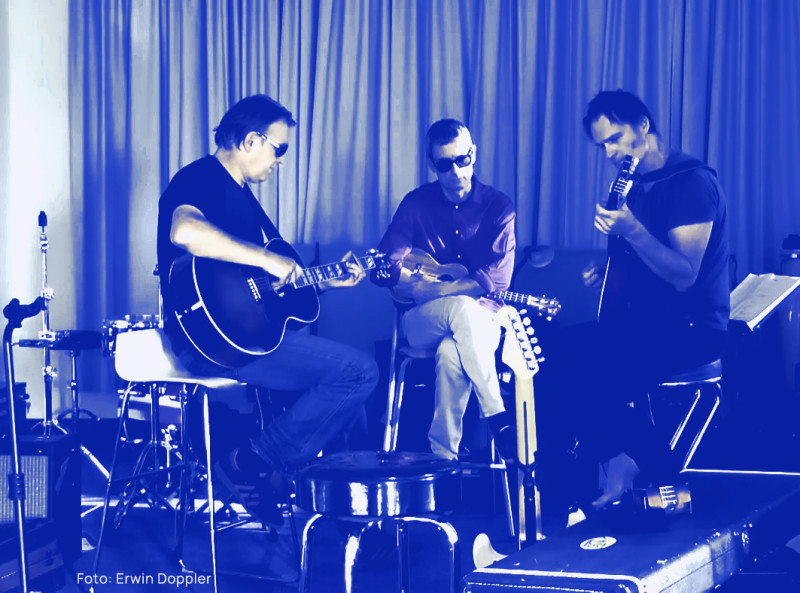 Andreas, Christian and Christoph sitting in a cosy looking rehearsal space and playing a song of theirs.