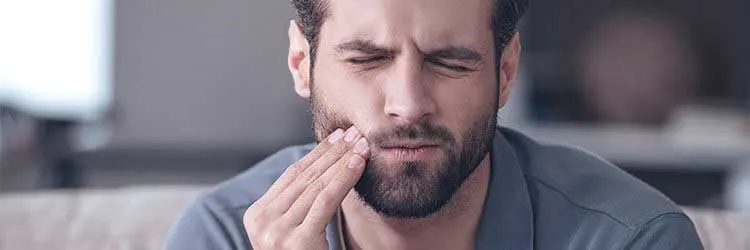 Diş eti çekilmesi nedeniyle acı çeken adam 