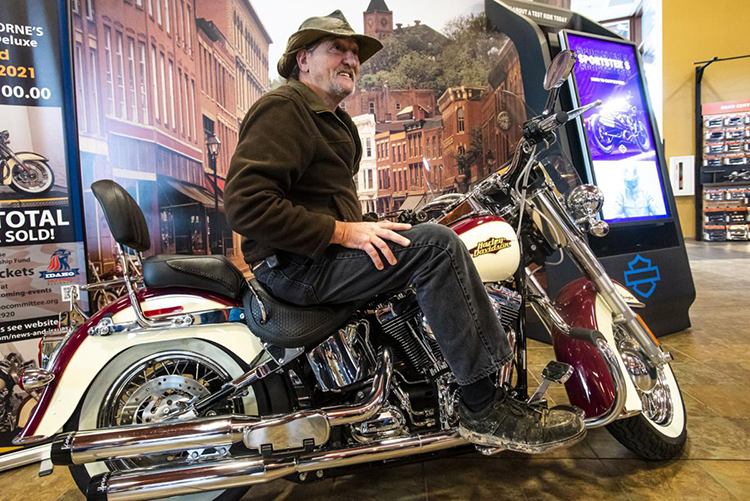 Steve Nible smiles and sits on a motorcycle he won in a Veterans Day Raffle at High Desert Harley Davidson in Meridian on Thursday.