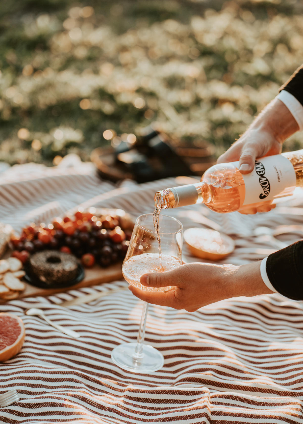 Pouring rosé wine on a picnic