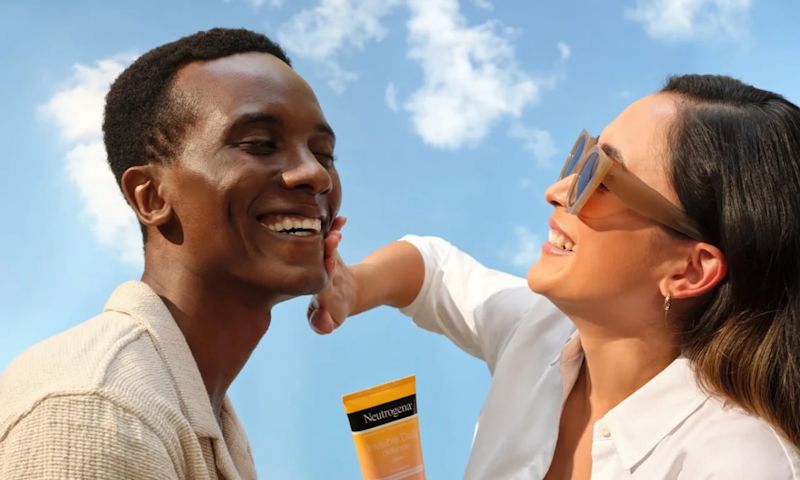 Woman applying Neutrogena® sunscreen to man’s face