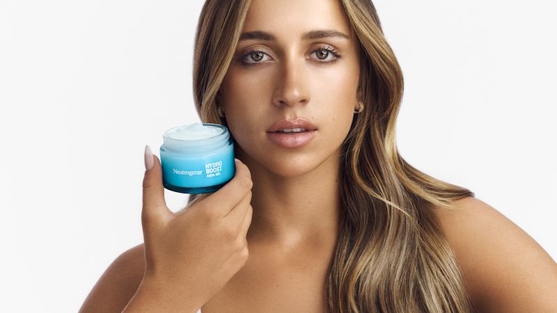 Tate McRae hält Neutrogena Hydro Boost Aqua Gel in der Hand und schaut in die Kamera​