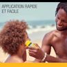 Père utilisant un écran solaire en bâton sur le visage de son enfant à la plage