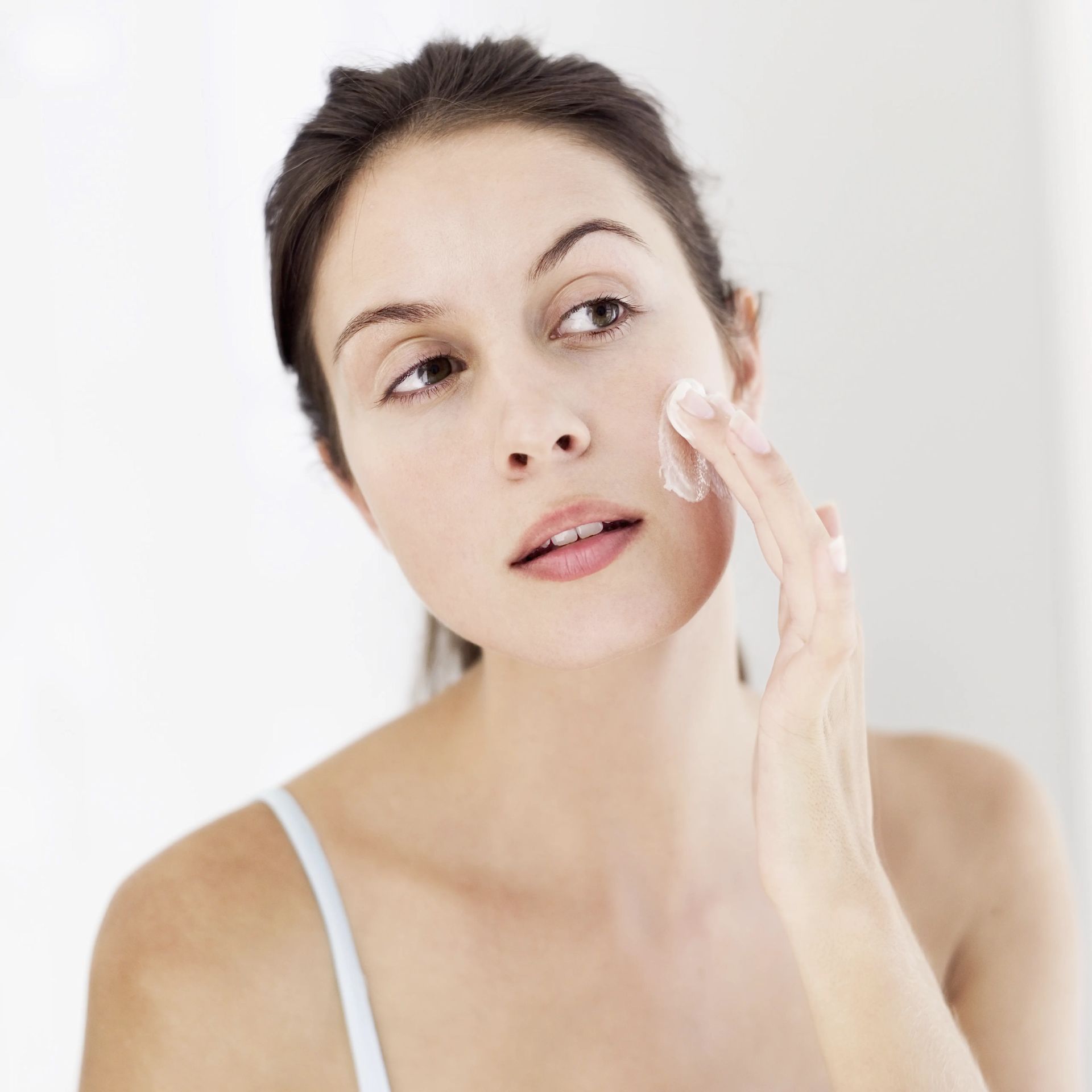 Junge Frau trägt Bodylotion auf Ihre Haut auf