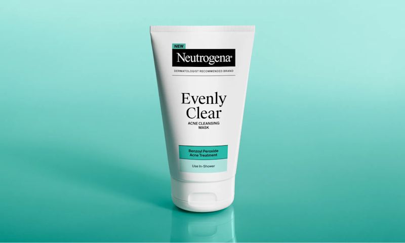Neutrogena® Evenly Clear™ Acne Cleansing Mask packaging against a teal background