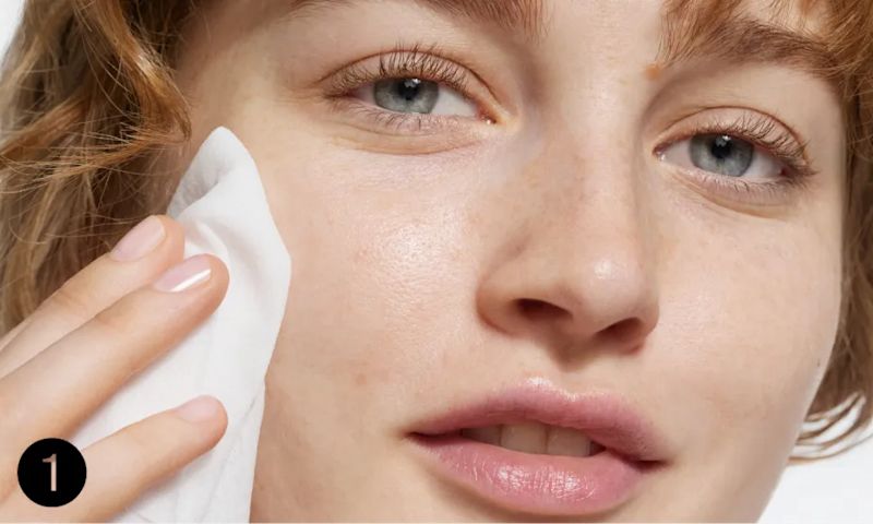 Woman gently pressing Hydro Boost Cleansing Wipe to face