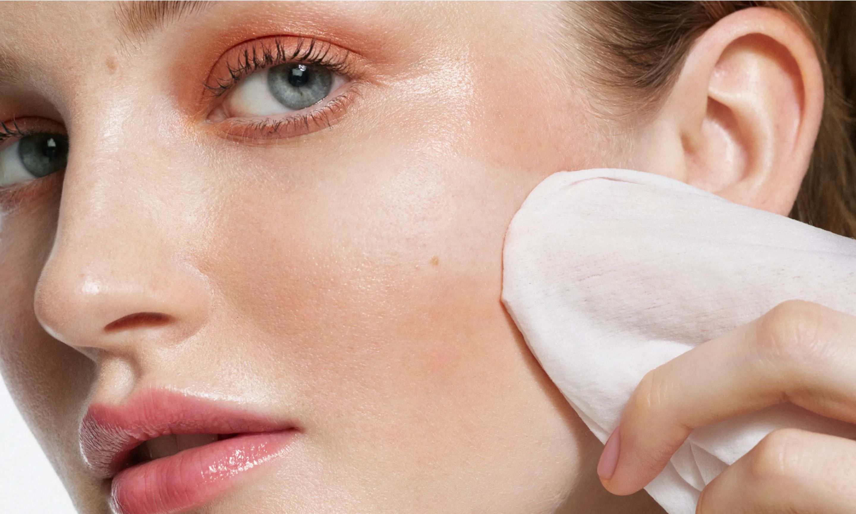 Woman applying wipe to face