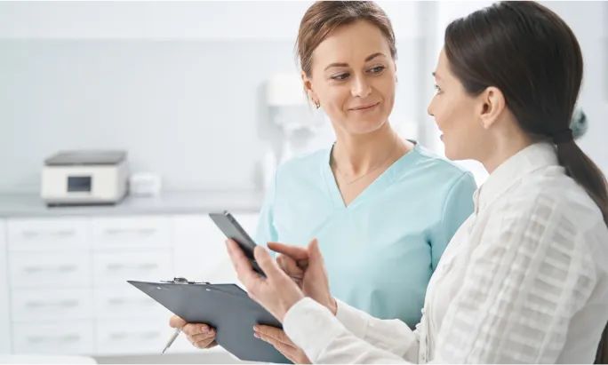 A woman discussion treatments with her dermatologist in an office