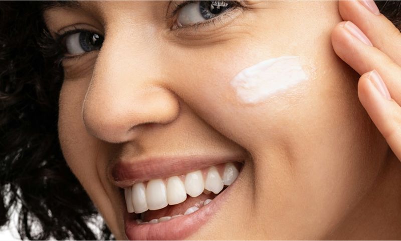 Woman using hydro boost water cream with hyaluronic acid to moisturize her face