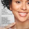A woman smiling with the text 'reveal visibly clearer, healthy glow'