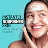 Young woman washing her face with a foaming cleanser while smiling