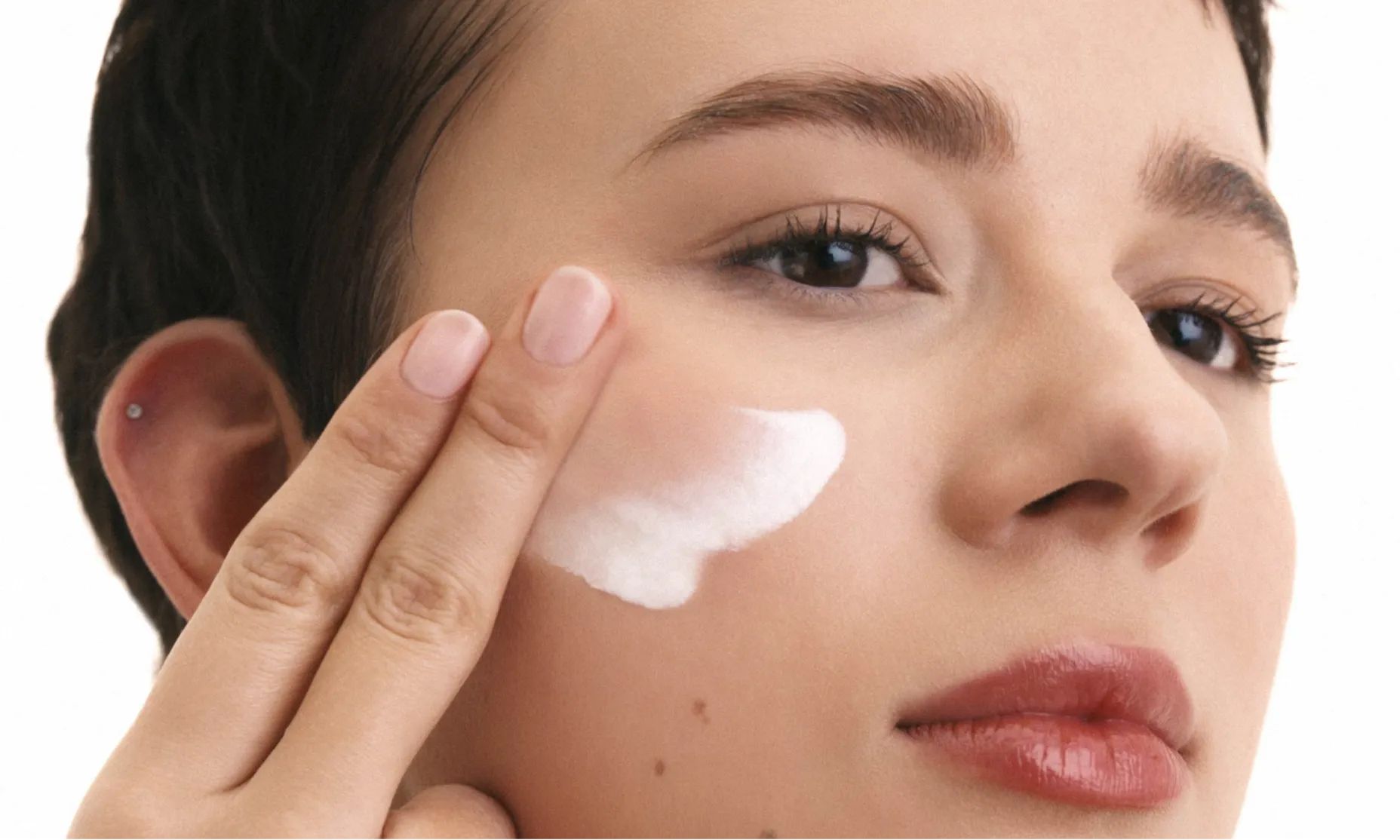 Woman applying Neutrogena® Cloud Tech™ Ultra Sheer® Daily Face Sunscreen to face