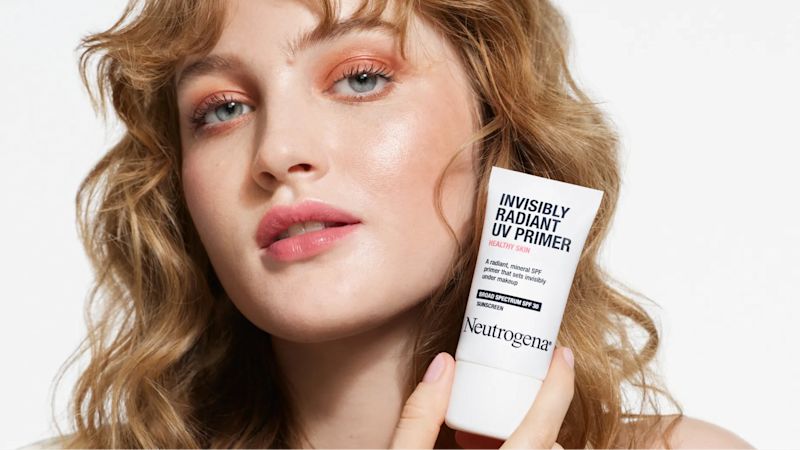 Woman with healthy skin holding Neutrogena® Healthy Skin Invisibly Radiant UV Primer SPF 30
