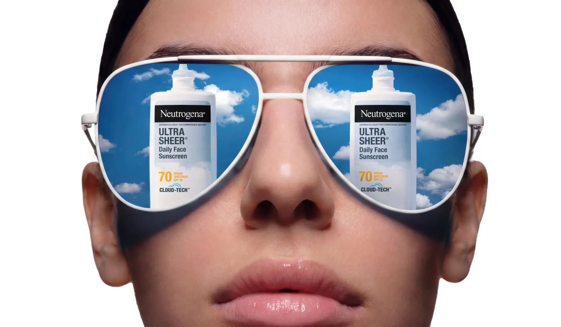 Woman wearing sunglasses reflecting the sky packaging of Neutrogena® Cloud Tech™ Bemotrinzinol BEMT sunscreen