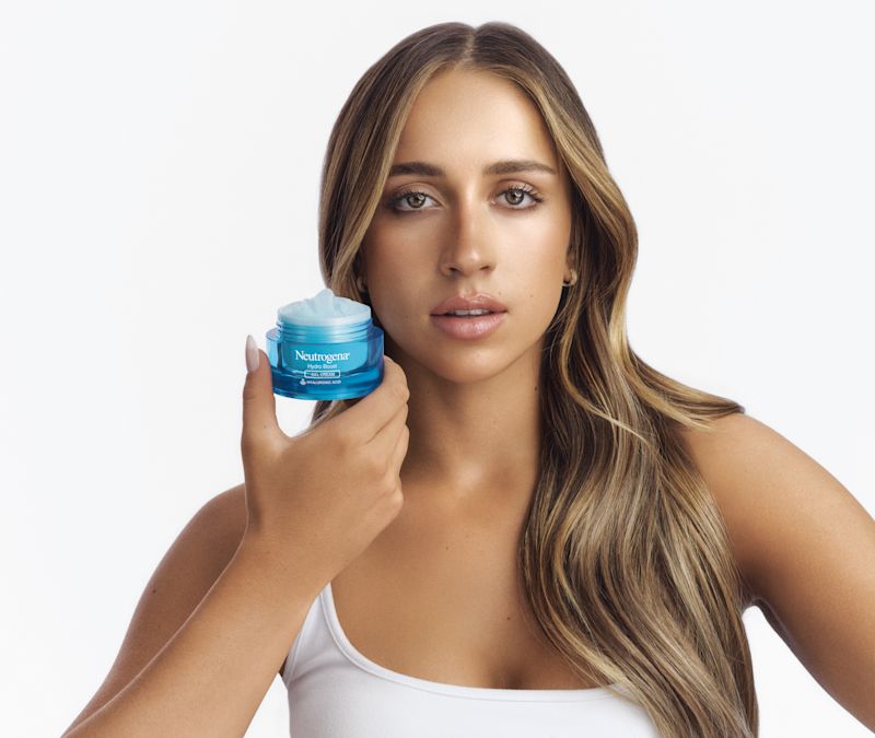 Tate McRae holding a jar of NEUTROGENA® Hydro Boost Gel Cream with an open lid