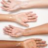 Four arms extended out showing Neutrogena® Purescreen+™ Mineral UV Tint Face Liquid Sunscreen swatches against skin colors.