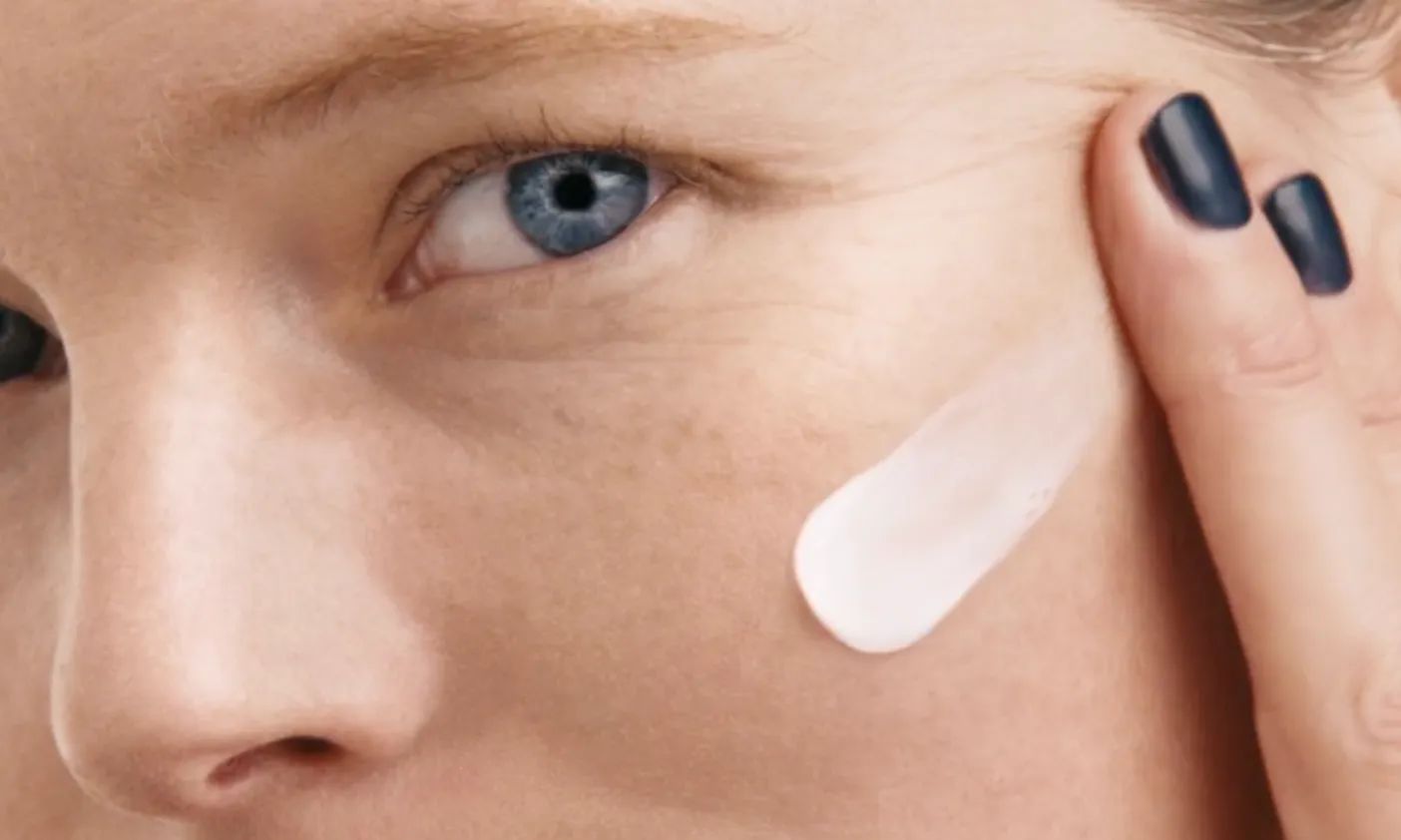 Woman with painted nails apply Neutrogena® Rapid Wrinkle Repair® Fragrance Free to face