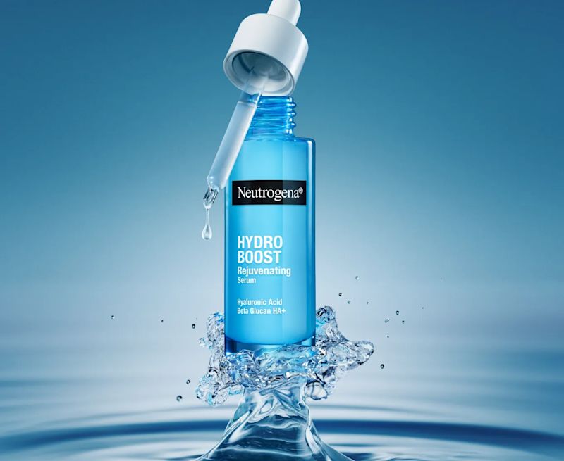 Neutrogena® Hydro Boost Rejuvenating Serum bottle and dropper being boosted into the air by a geyser of water