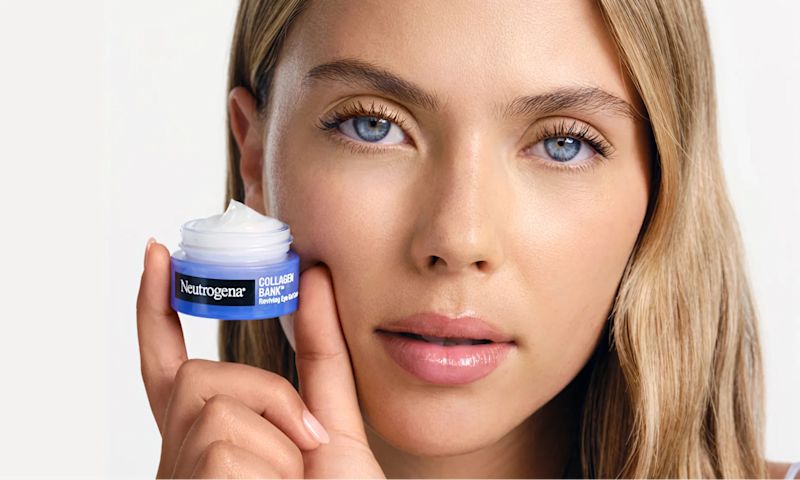 young women holding a small, blue jar of Neutrogena's Collagen Bank Reviving Eye Gel Cream