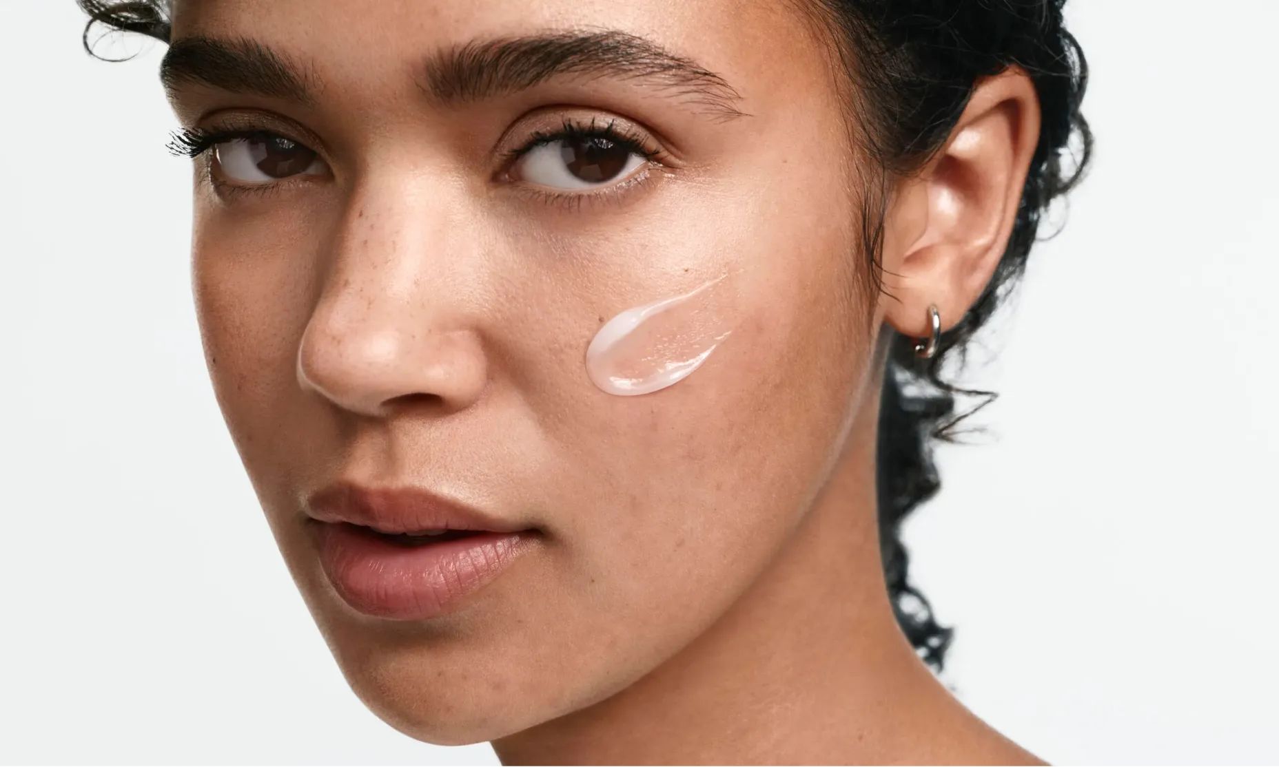 woman applying Neutrogena® acne cream to face