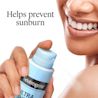 Smiling person holds Neutrogena® Ultra Sheer® spray sunscreen; Helps prevent sunburn