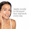 Smiling woman applying cream with instructions to apply evenly to cleansed face and neck daily.