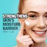 Young woman applying Neutrogena® Ultra Gentle Moisturizer on her face and smiling