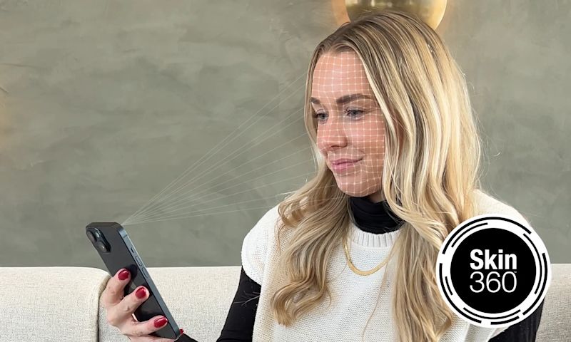  A young person holding a smartphone to their face, with a digital grid overlaid on their skin for a skin analysis, and a "Skin360" logo in the bottom right corner.