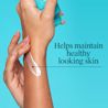 Hand applies white lotion on forearm; Helps maintain healthy looking skin