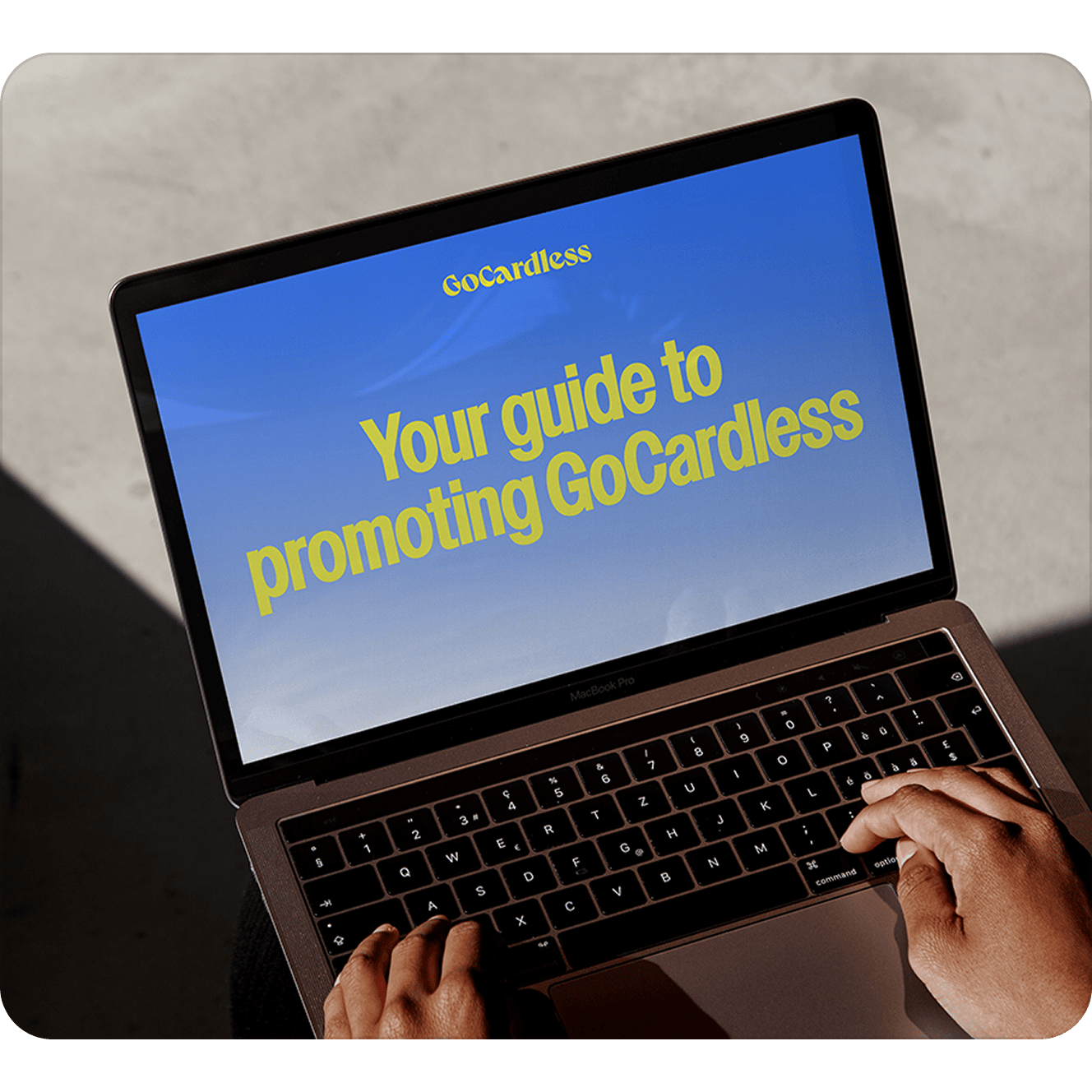 A laptop screen with the words "Your guide to promoting GoCardless" 