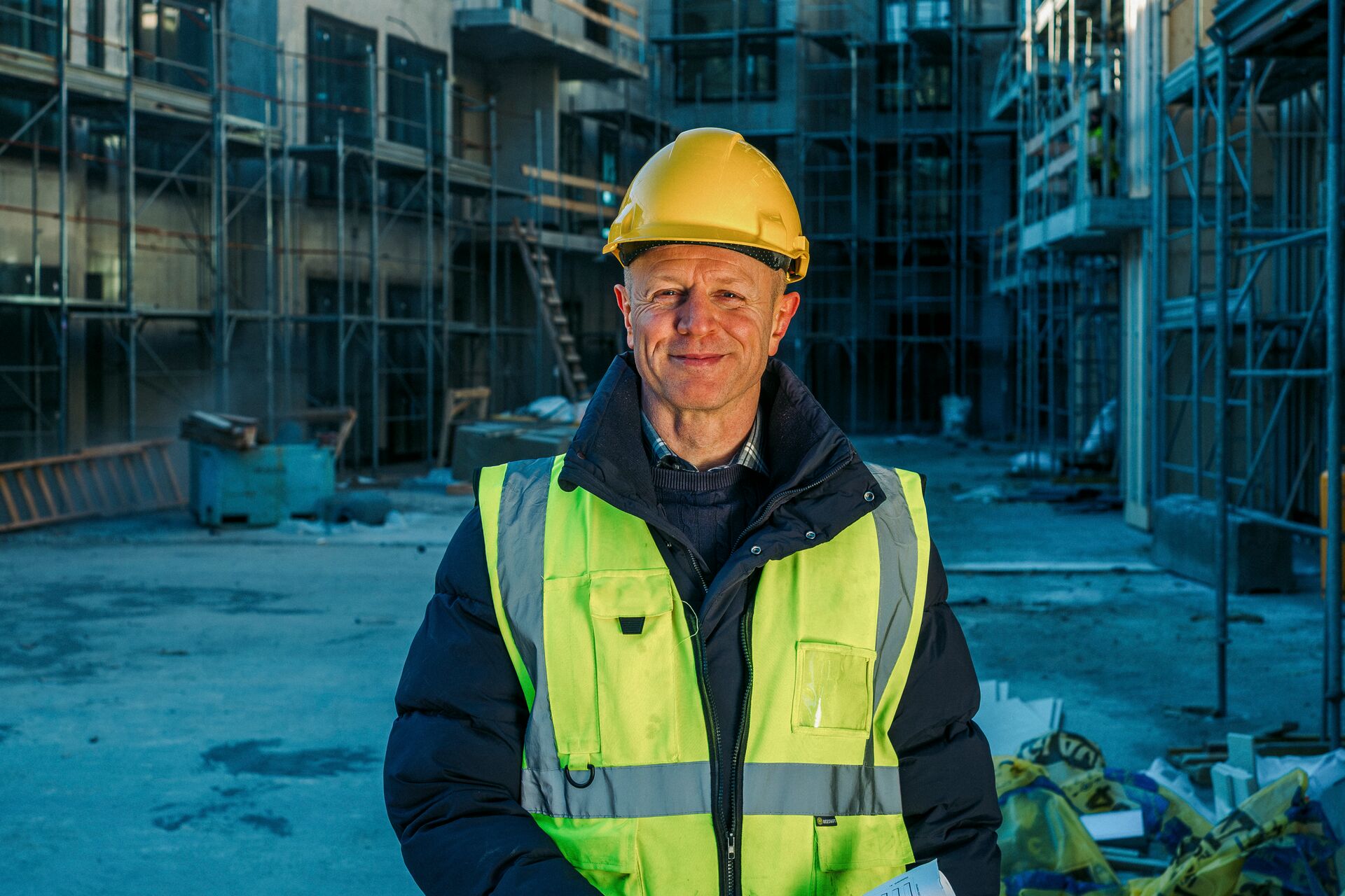 Verktaki á byggingarsvæði brosandi