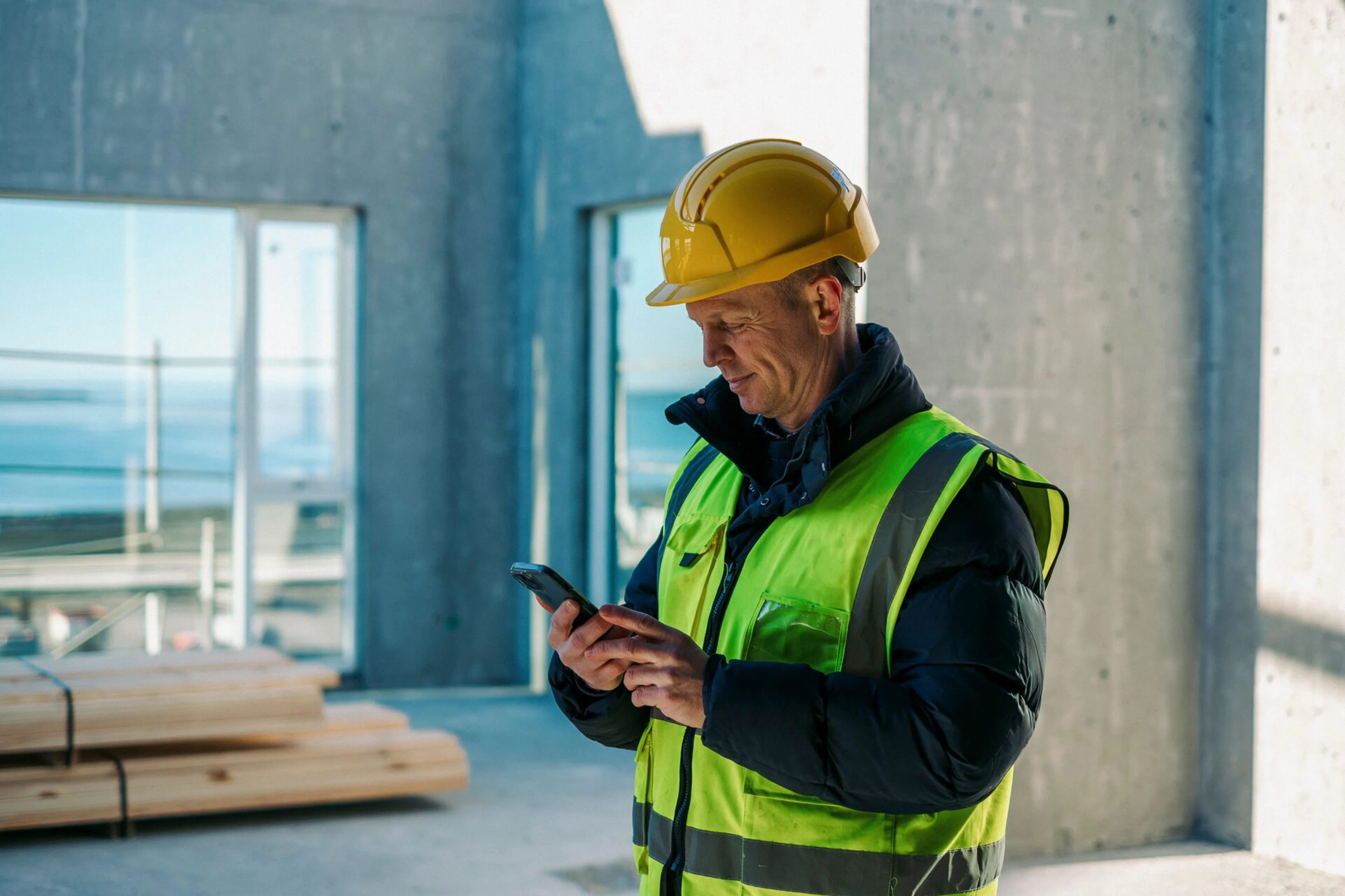 Verktaki að horfa í símann á byggingarsvæði