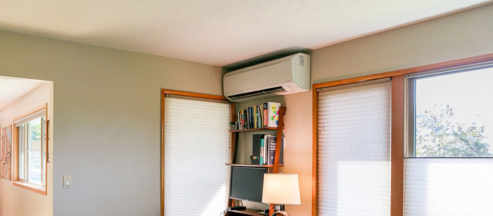 Heat pump above a computer and bookshelf with a newly installed thermostat
