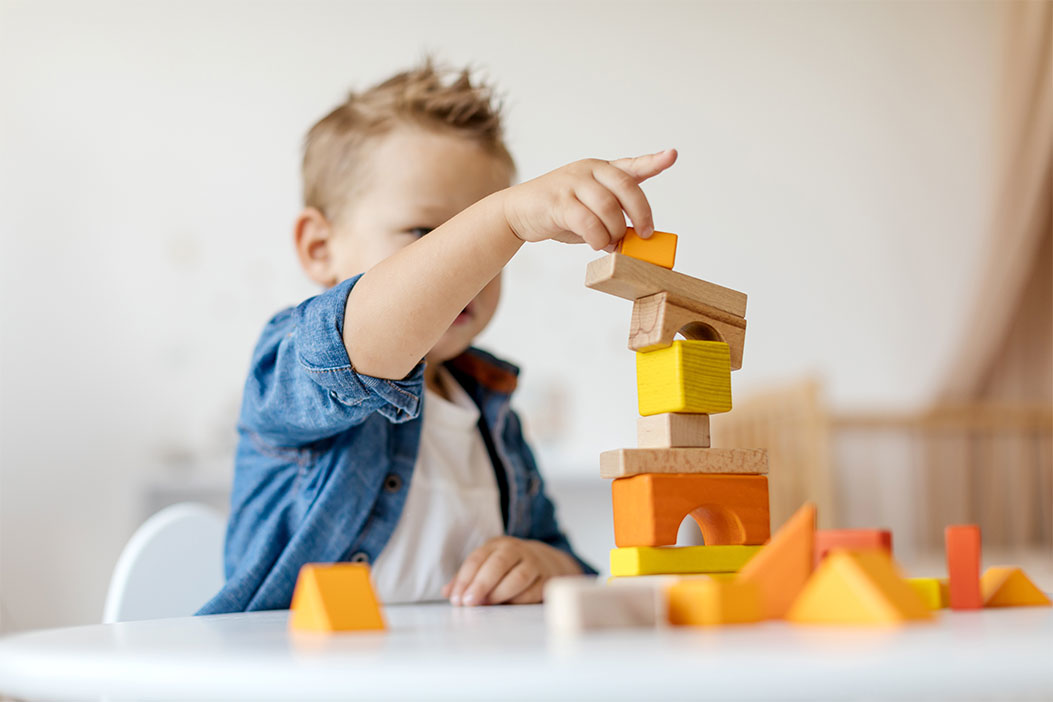 Niño jugando a montar una torre con piezas