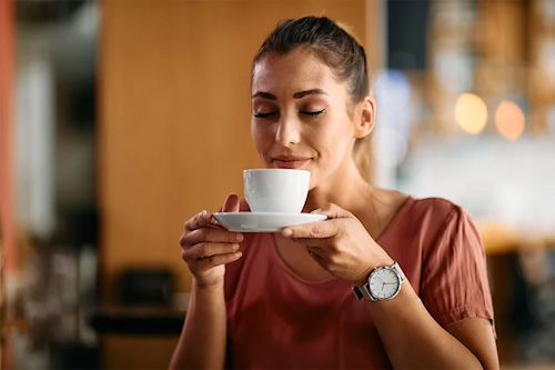 Mujer tomando café, hábito que puede influir en la absorción de hierro.