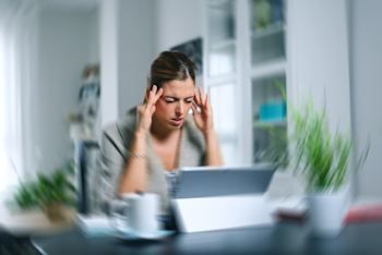 Mujer sentada sufriendo dolor de cabeza