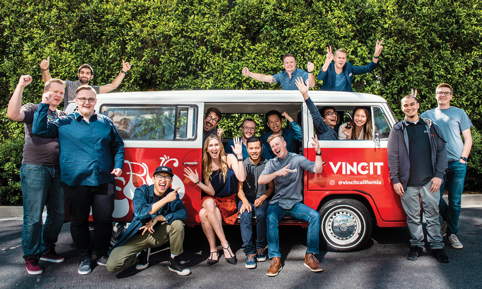 Software developers posing inside and around a red and white van branded with the Vincit logo Source: Irvine Standard
