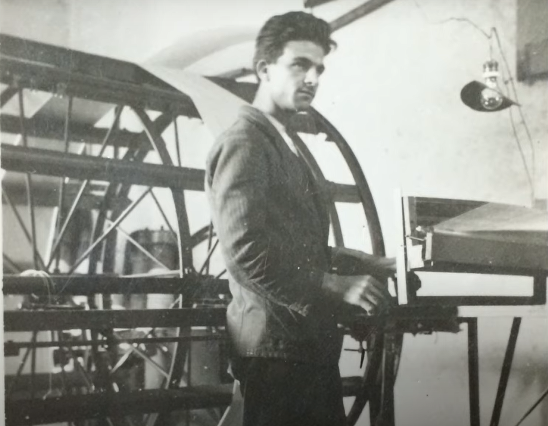 black and white image of man by textile machinery