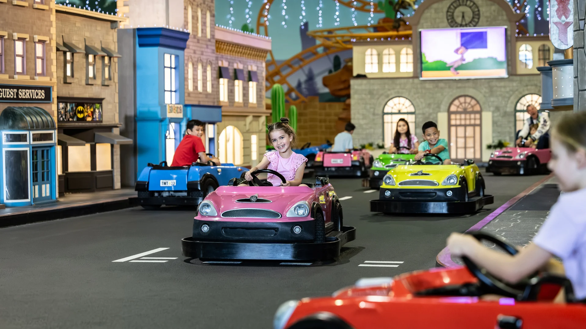 Children enjoying a fun ride as they drive around a miniature movie world at Junior Driving School, adding to the excitement of Warner Bros. Movie World