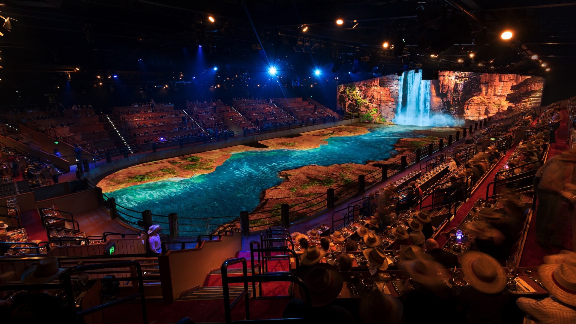 Immersive Australian Outback Spectacular arena with stunning projection-mapped river and waterfall scene as diners watch the show.