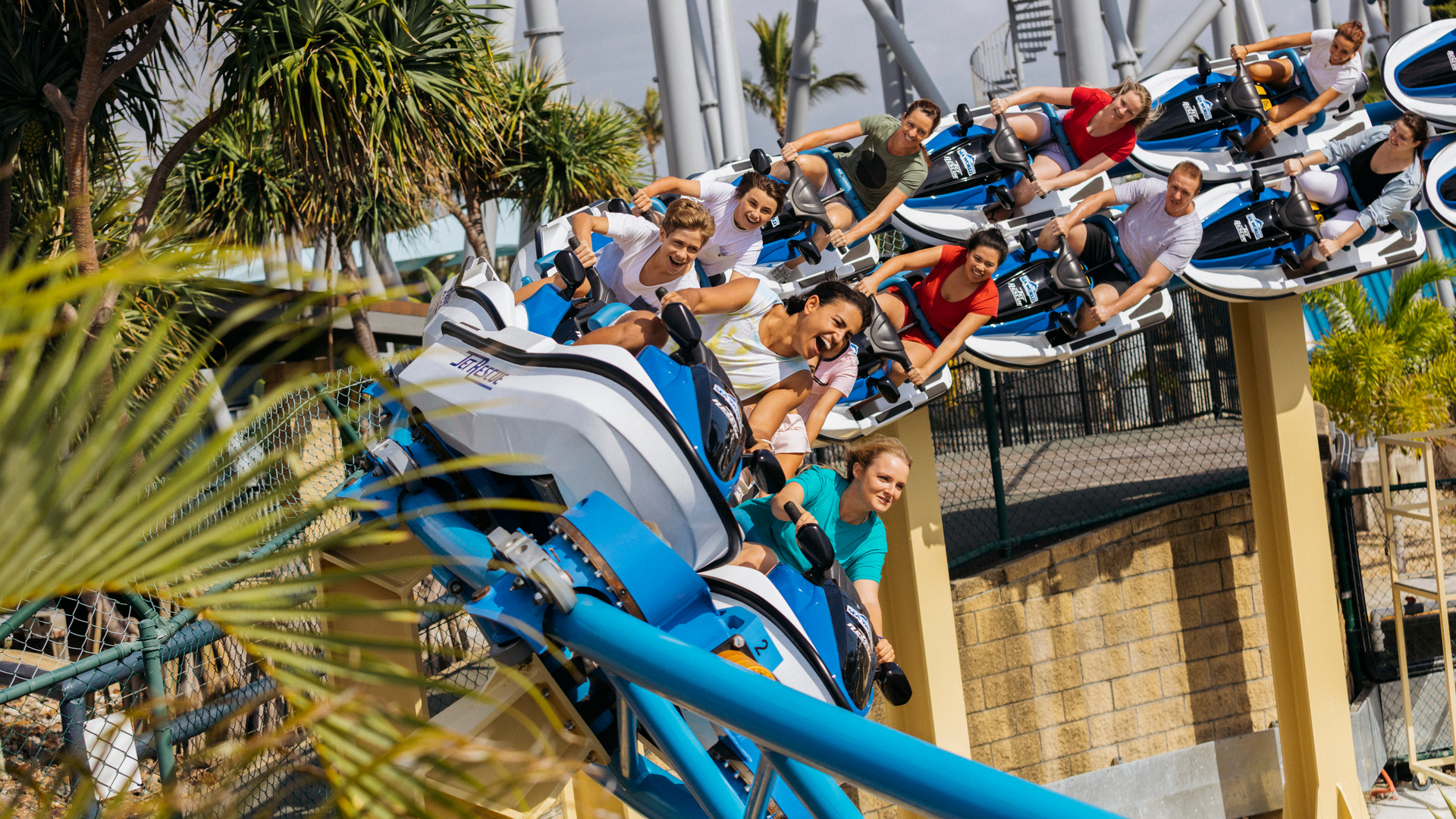 Thrill-seekers riding the Jet Rescue roller coaster at Sea World, leaning into twists and turns on jet ski–style seats.