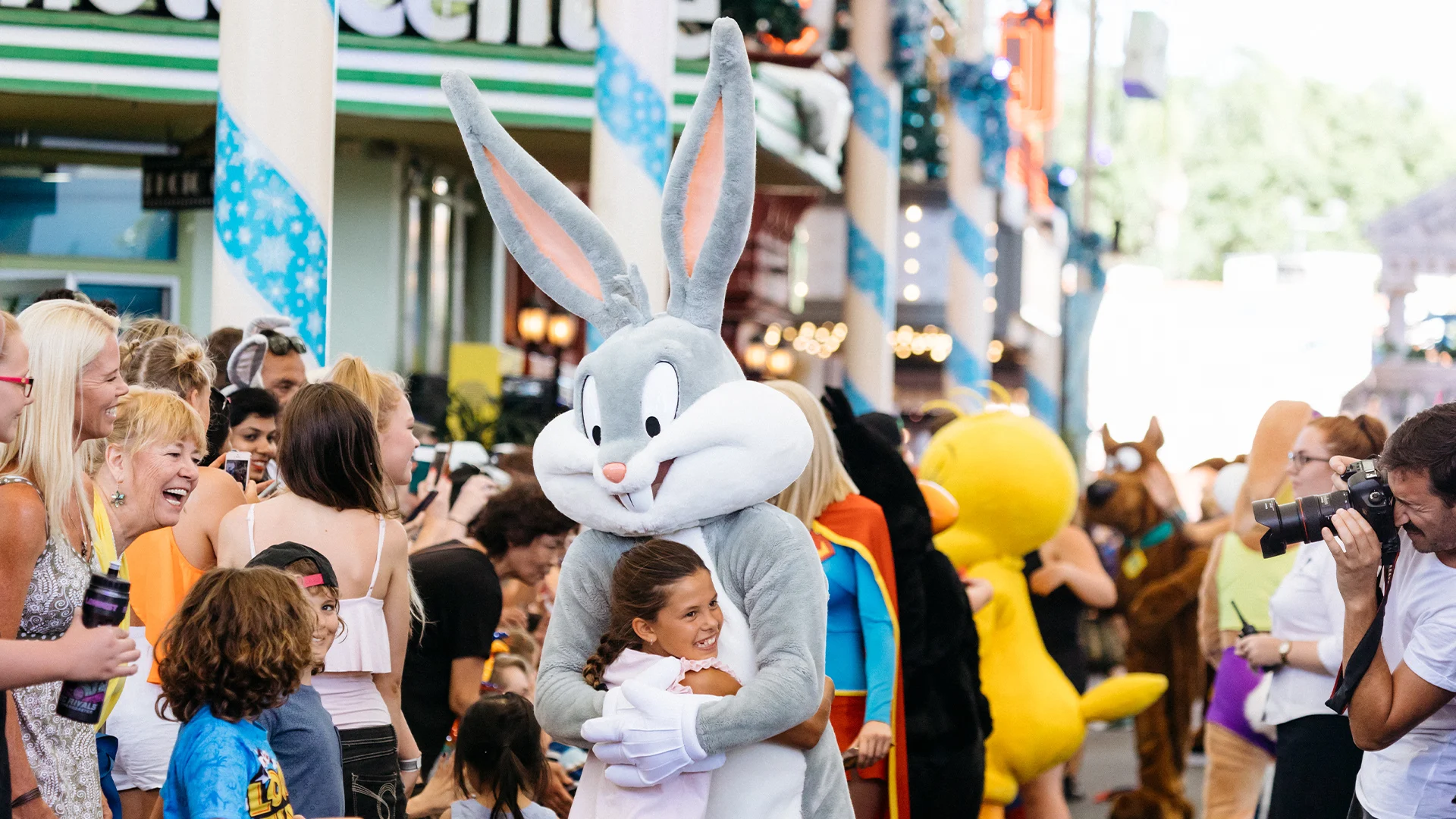 A smiling child joyfully embraces Bugs Bunny during the Star Parade on Main Street at Warner Bros. Movie World
