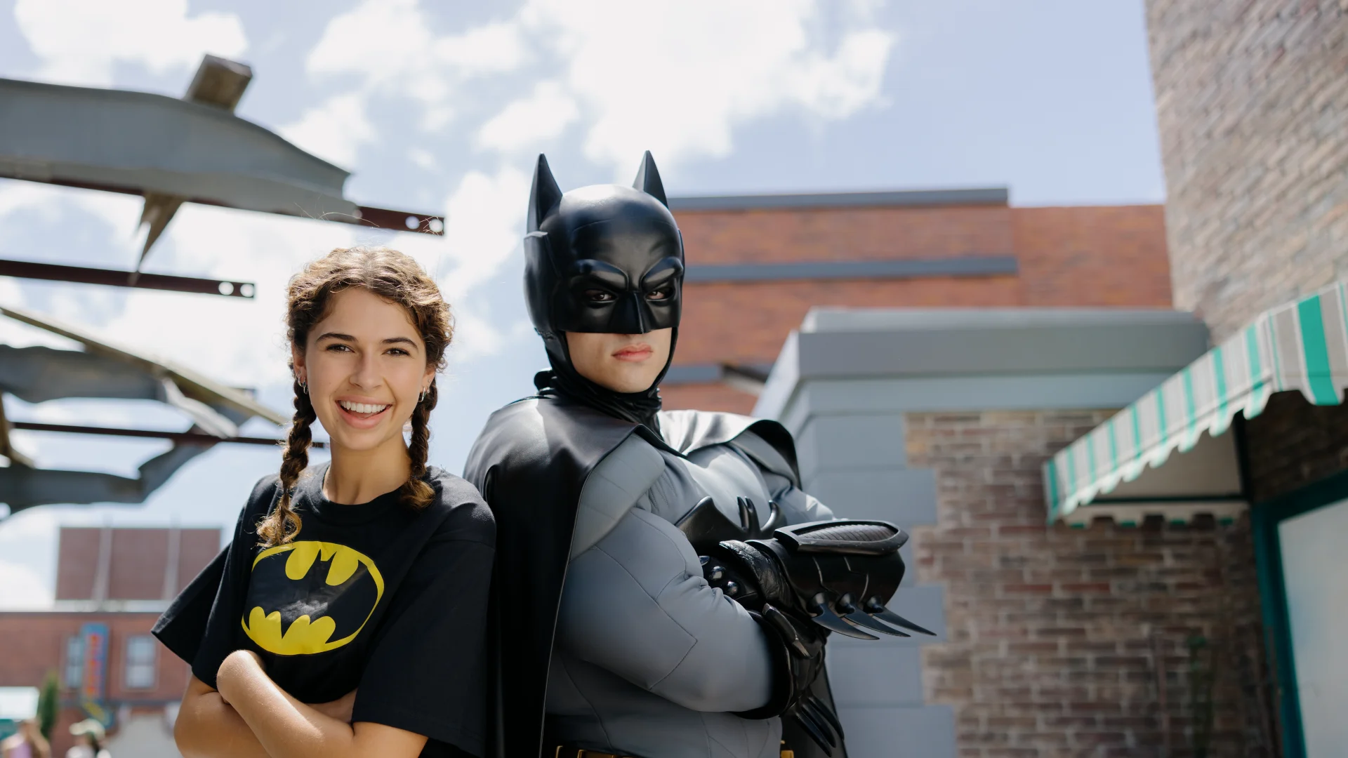 A woman in a batman shirt stands next to batman