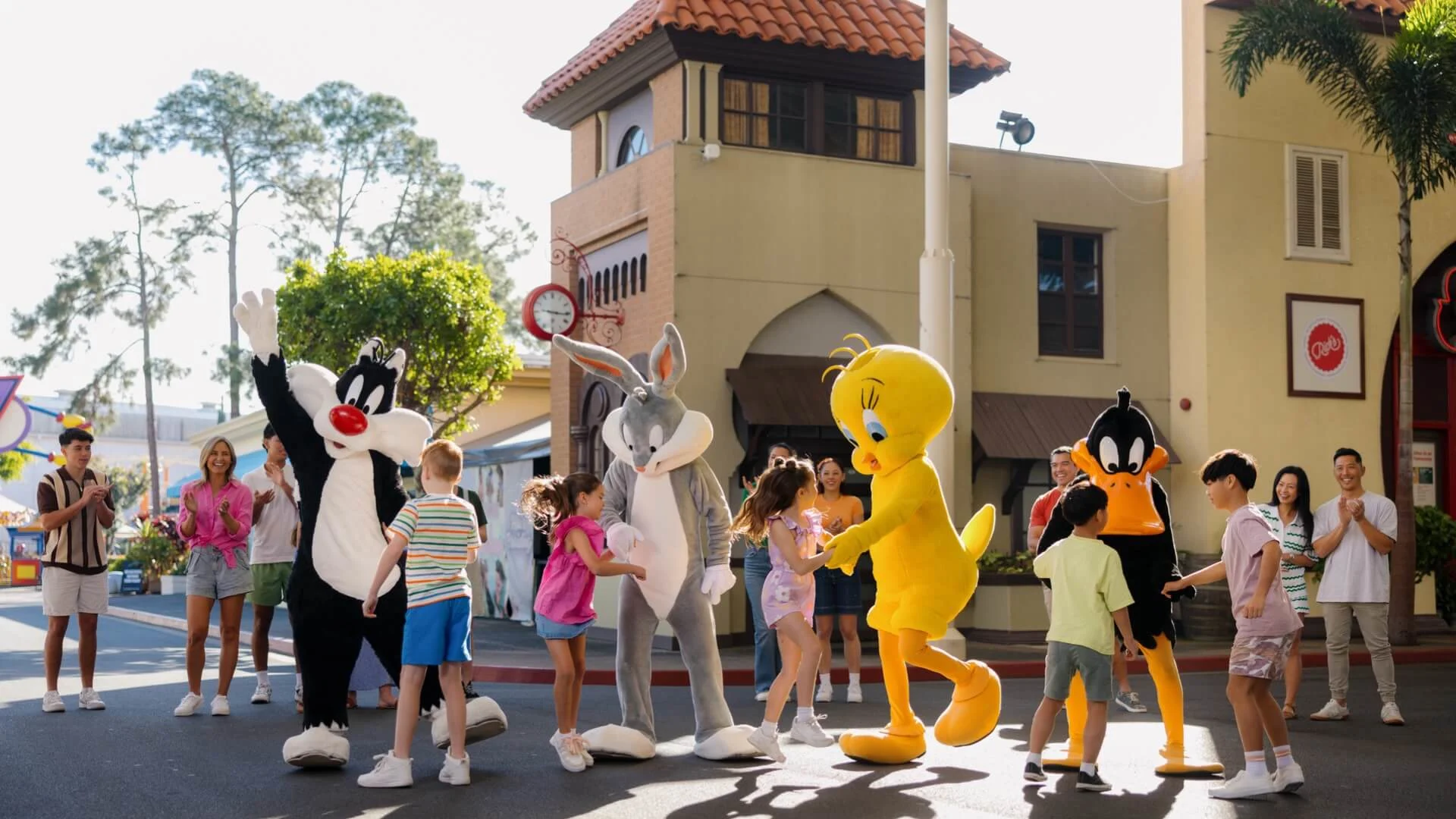 Families and children dancing with Looney Tunes characters Bugs Bunny, Tweety, Daffy Duck, and Sylvester at Warner Bros. Movie World on the Gold Coast.